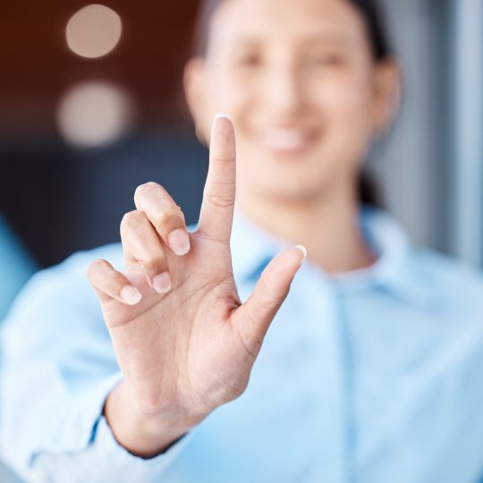 technology-business-and-a-finger-on-a-touch-screen-on-a-screen-a-woman-with-a-smile-blurred-in-th
